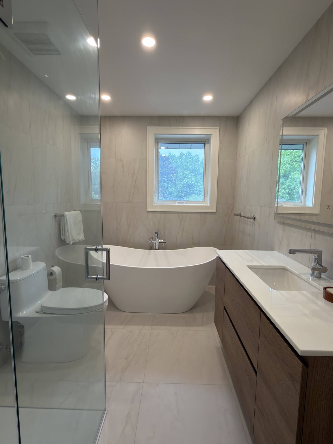 Modern bathroom renovation with freestanding tub, glass shower and double-length vanity