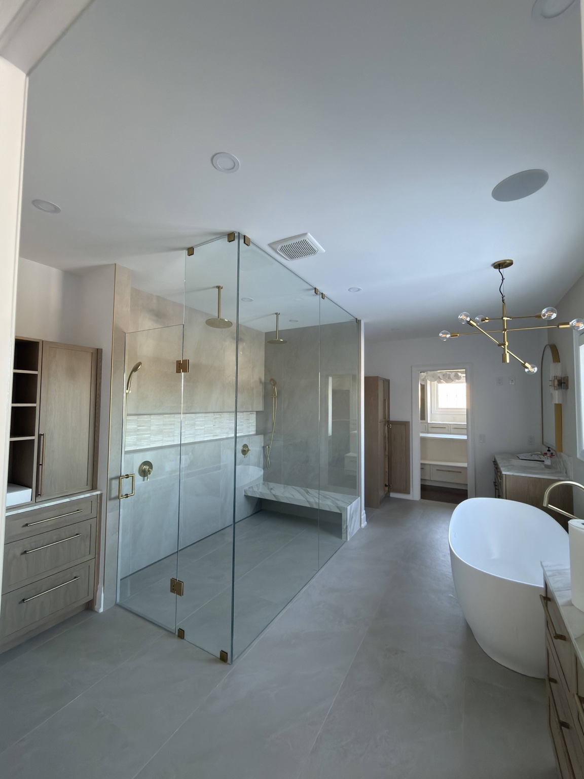 Luxury bathroom renovation with oversized custom glass shower, freestanding bathtub and contemporary fixtures